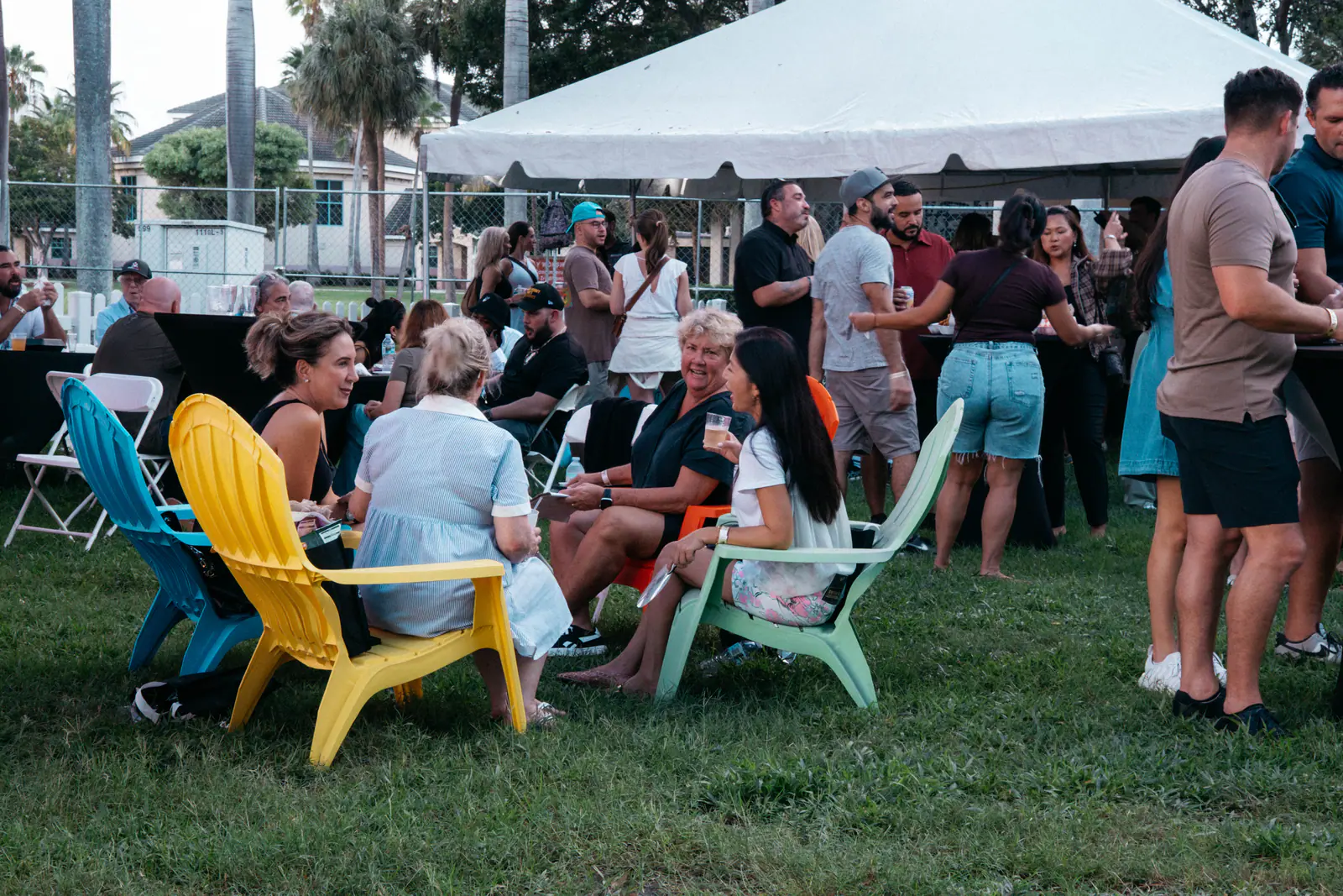 Guests relaxing in colorful lawn chairs beside the tasting tents