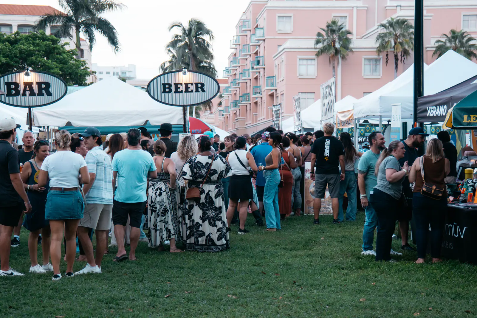 A crowd in front of the bar and beer tents at Mizner Park