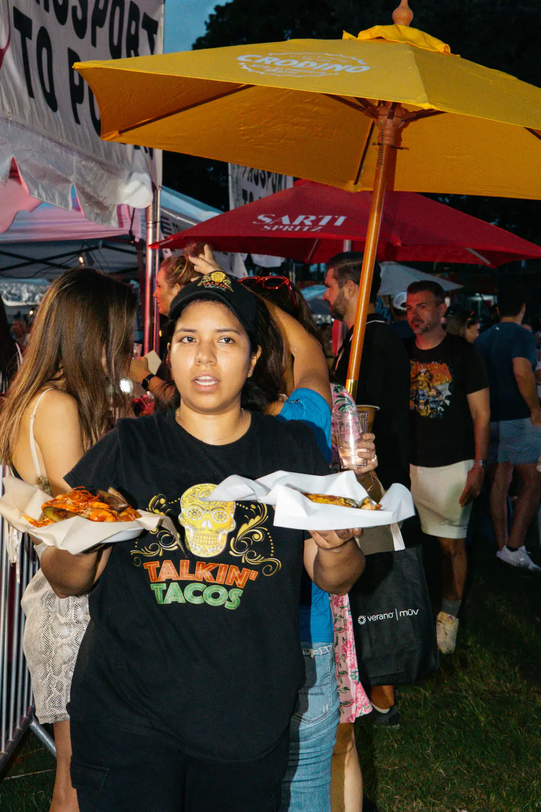 A guest holding two plates of tacos