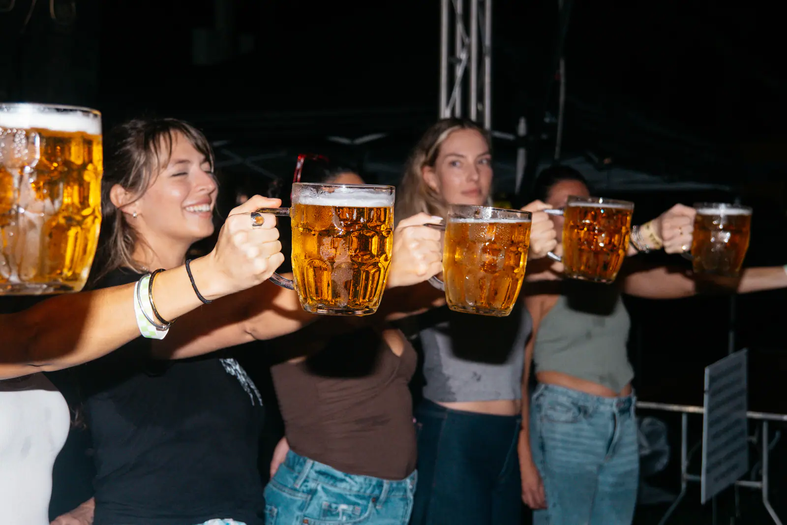 Guests holding full beer steins at arm’s length
