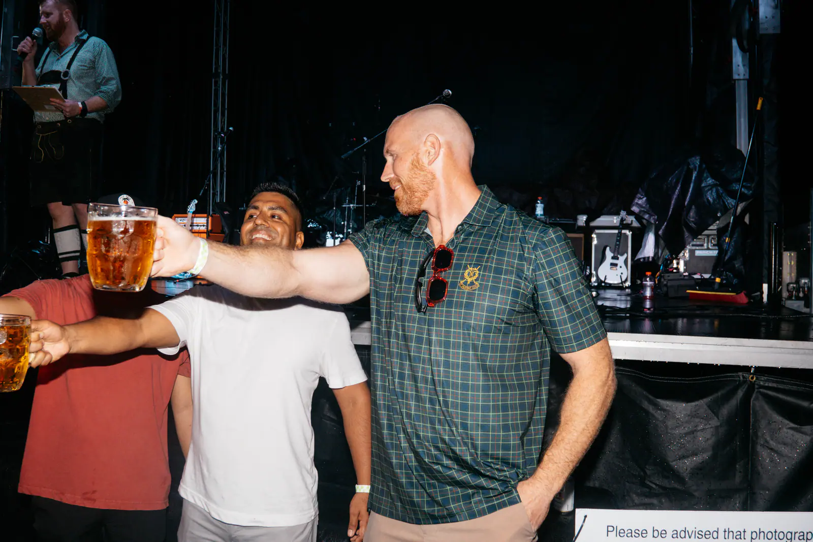 Guests holding beer steins beside the stage
