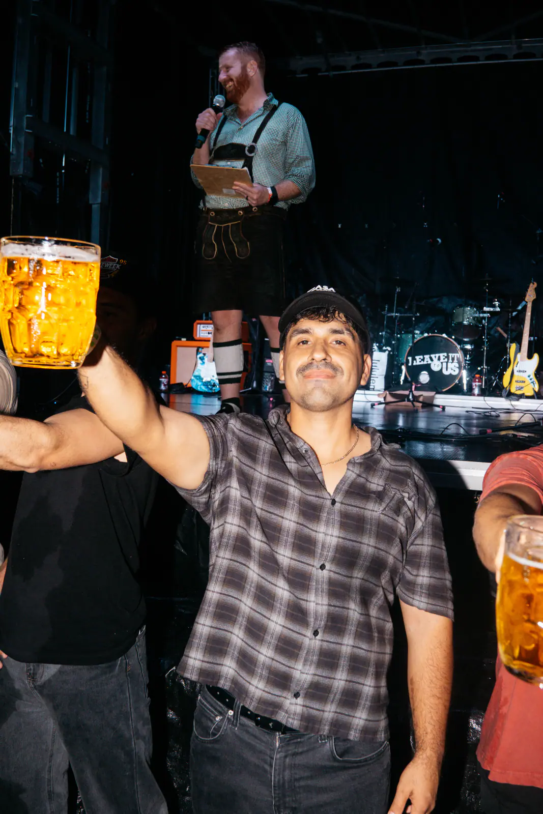 A guest raising a full beer stein in front of the stage